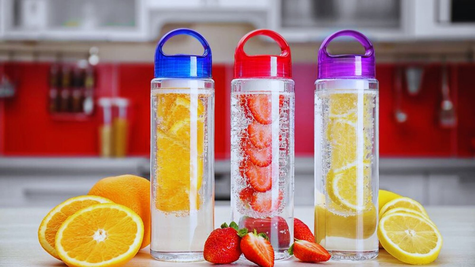 Three clear bottles of water infused with various fruits, showcasing vibrant colors and refreshing ingredients.