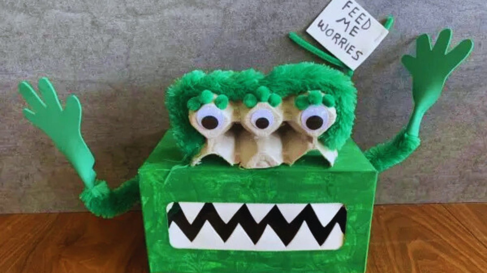 A green monster box featuring a playful monster face with large eyes and a wide grin.